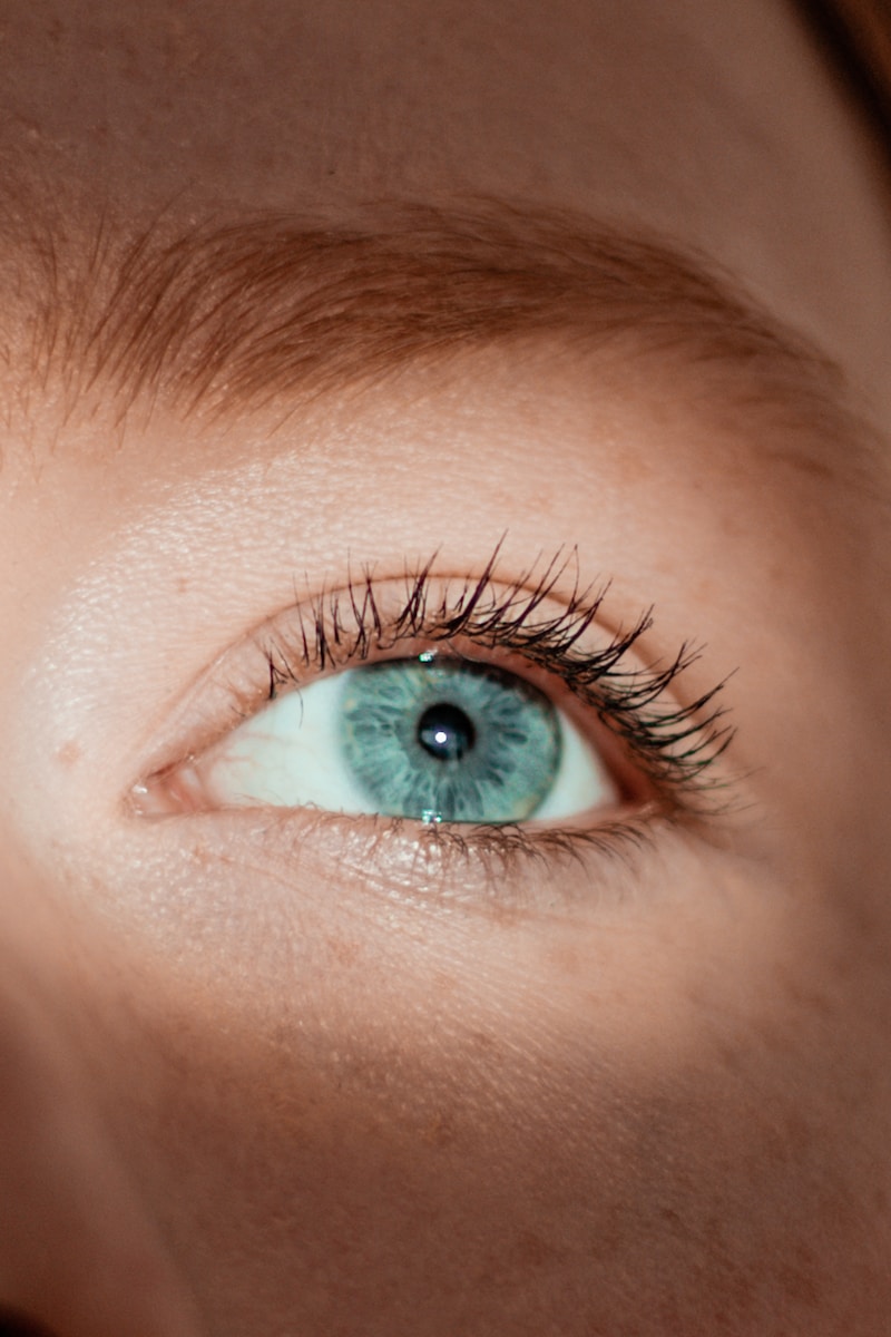 persons green eye in close up photography